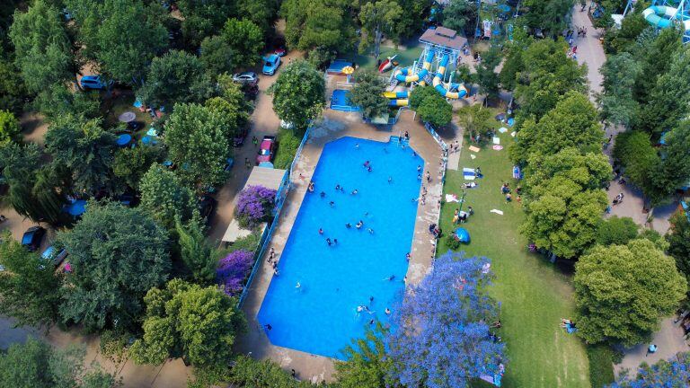 Vista aérea de la piscina Acuasol, con césped y quitasoles alrededor